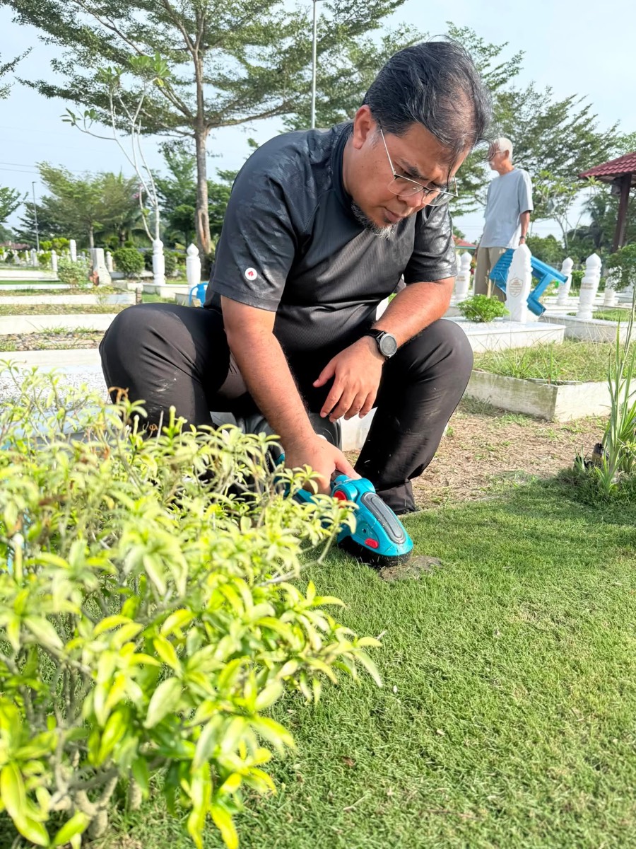 Mohd Effandi tending to his daughter's grave during the family's weekly visit to the cemetery