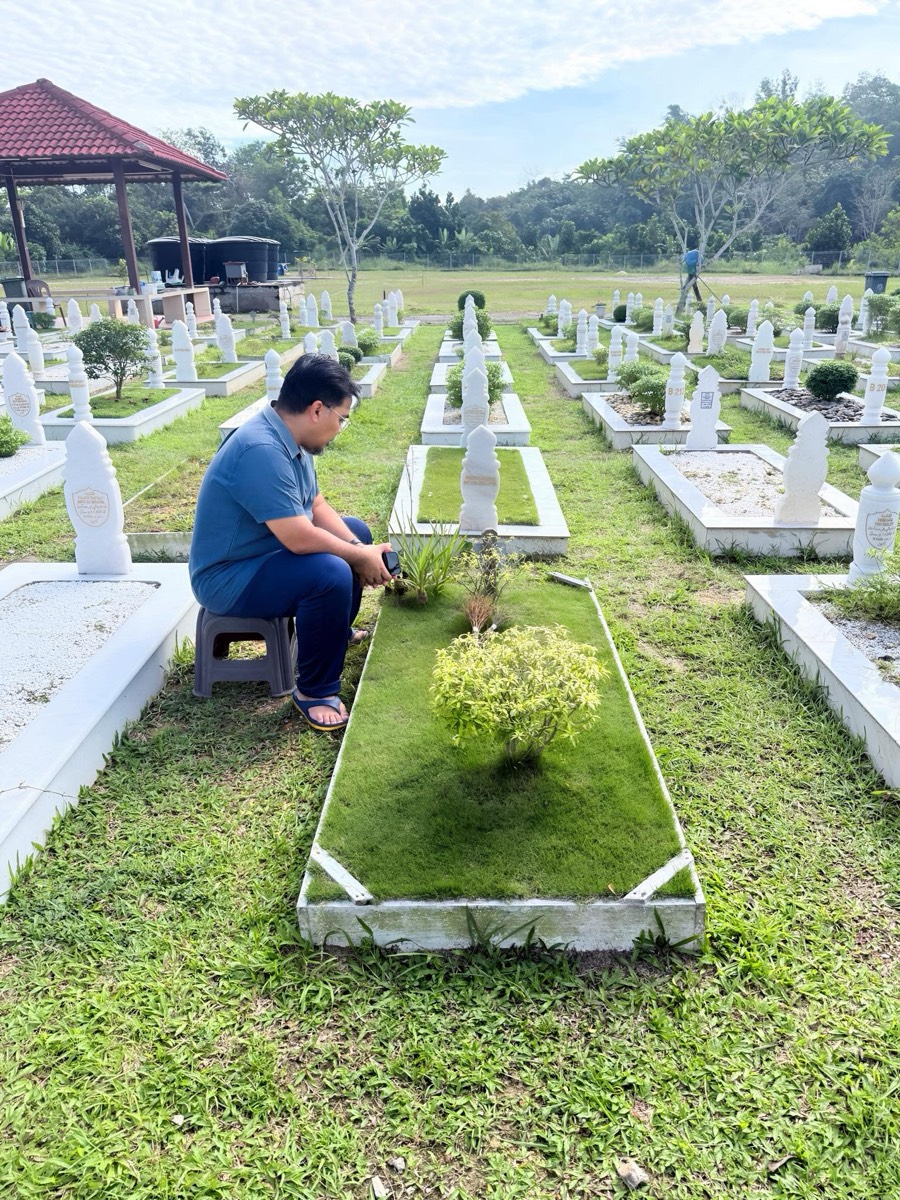 Mohd Effandi visiting his daughter's grave at the Muslim cemetery
